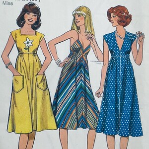 May include: Vintage sewing pattern featuring three dresses. The first is a yellow midi dress with pockets and a floral detail. The second is a striped maxi dress. The third is a blue polka dot dress with a zipper.