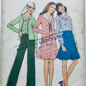 May include: Vintage sewing pattern featuring three women wearing different outfits. The woman on the left is wearing a green jacket, a plaid shirt, and green trousers. The woman in the middle is wearing a pink jacket, a patterned sweater, and a pink skirt. The woman on the right is wearing a blue and white patterned blouse and a blue skirt. The pattern is from Alexandra Fabrics Ltd.