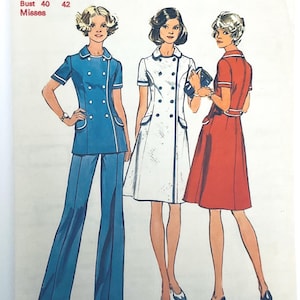 Può includere: Una busta per cartamodello con illustrazioni di tre outfit: una tunica blu a doppio petto con pantaloni abbinati, un abito bianco a doppio petto e un abito rosso con finiture bianche. Il testo riporta Bust 40 42 Misses.