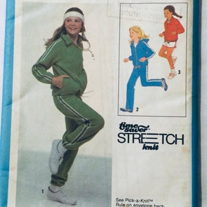 Può includere: Un modello di cucito vintage per una tuta con una giacca e pantaloni verdi, una giacca e pantaloni blu e una maglietta e pantaloncini rossi. Il modello è per tessuto a maglia elasticizzato e include istruzioni per una regola "Pick-a-Knit".
