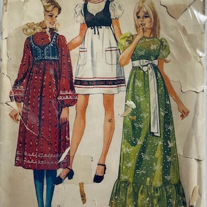 Cute dress with high round neckline and either short very puffy sleeves or set in sleeves with puffy gathers at wrist. Gathered high waist and optional gathered lower skirt band. Patch pockets, trim and lined bolero.