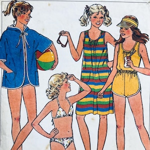 Può includere: Un cartamodello per quattro diversi abiti estivi per ragazze. Il cartamodello include un copricostume da spiaggia con cappuccio, un abito estivo a righe, un costume da bagno con pantaloncini e un top e un fondo bikini. Il cartamodello è illustrato con quattro ragazze che indossano i diversi abiti.