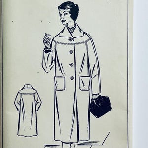 Op de afbeelding: Vintage mode-illustratie van een lange jas met een reverskraag, knoopsluiting en zakken. De zwart-wit tekening bevat een kleinere illustratie van de achterkant van de jas. De jas wordt gecombineerd met een handtas.