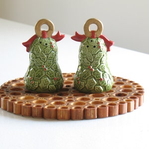 May include: A set of two ceramic Christmas bell salt and pepper shakers. The bells are green with holly leaves and red berries. They have gold rings and red bows.