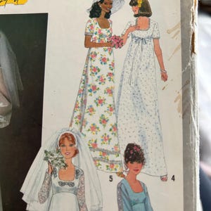May include: Vintage sewing pattern with illustrations of women's dresses. The dresses include a floral print maxi dress, a dotted maxi dress, a bridal gown with a veil, and a light blue dress. The pattern number is 8392.