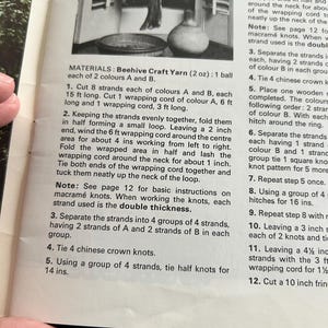 Op de afbeelding: Een zwart-wit afbeelding van een pagina met knutselinstructies. De tekst geeft instructies voor een macram&eacute;project met Beehive Craft Yarn. De instructies omvatten het knippen van strengen, het vormen van lussen en het knopen van knopen.