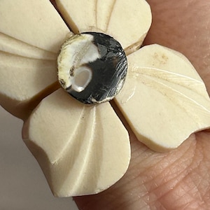 Op de afbeelding: Een gegraveerde witte bloemenring met een zwart-witte agaat-steen in het midden.