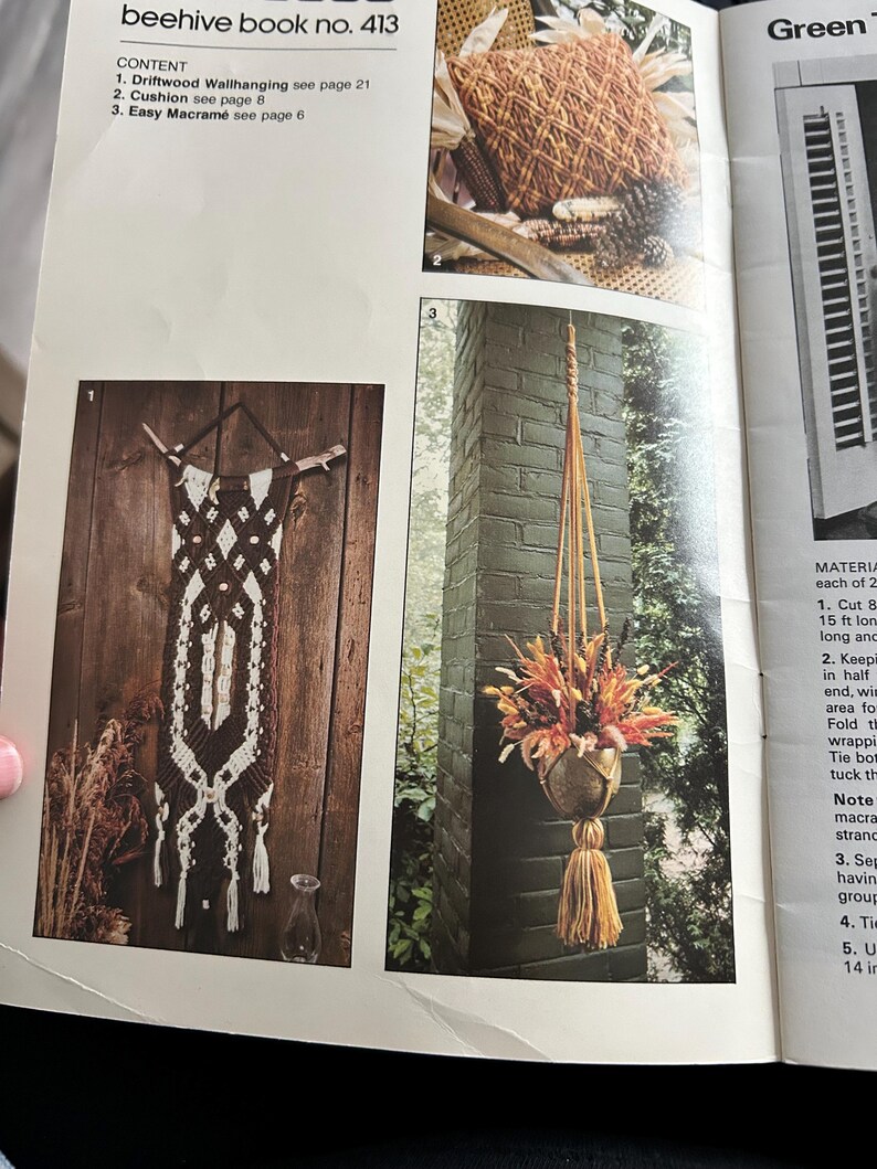 Op de afbeelding: Een pagina uit een knutselboek getiteld "beehive book no. 413" met macram&eacute;-projecten. De pagina bevat afbeeldingen van een wandkleed van drijfhout, een kussen en een hangende plantenbak met gedroogde bloemen. De tekst bevat de inhoud van het boek.