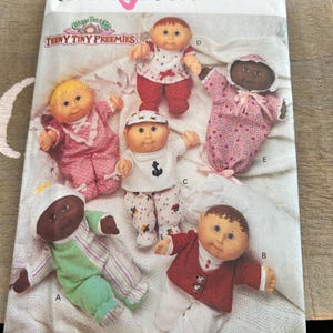 May include: A set of three ceramic mugs with a speckled, matte finish. The mugs are in shades of cream, light brown, and dark brown. Each mug has a simple, minimalist design and a rounded handle.