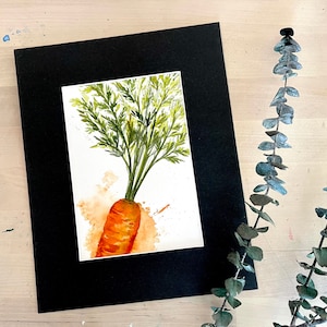 May include: A watercolor painting of a carrot with green leafy tops. The carrot is orange and the leaves are green. The painting is on a white background with a light orange watercolor wash.