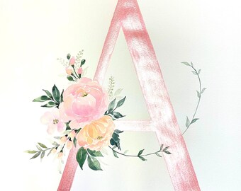 Puede incluir: Una pintura de acuarela de la letra A en rosa con un arreglo floral de flores rosas y amarillas y hojas verdes.