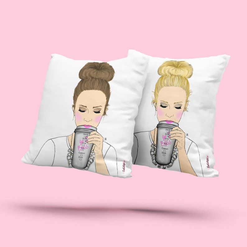 May include: Two white throw pillows with a graphic design of a woman with a messy bun drinking from a coffee cup that says "Girl Boss".