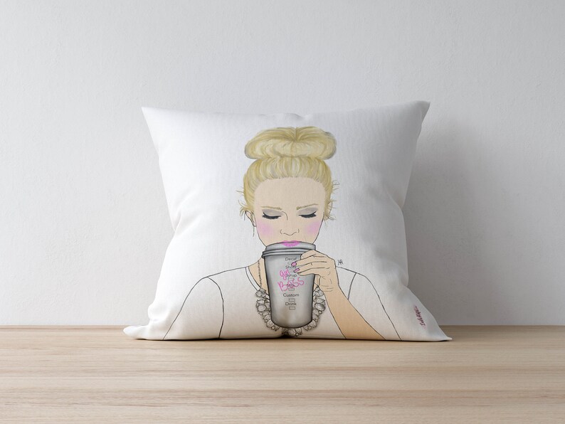 May include: White throw pillow with a drawing of a woman with blonde hair in a bun, wearing a white shirt and a silver necklace, holding a coffee cup with the text "Don't smile, it's just coffee" printed on it.