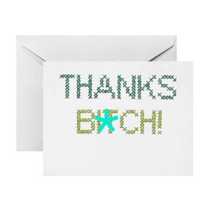 May include: A white card with the text "THANKS B*TCH!" in green and blue cross-stitch lettering. The asterisk is turquoise.