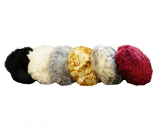 May include: Six round, fluffy, faux fur cushions in various colors: black, white, gray, gold, light gray, and burgundy.
