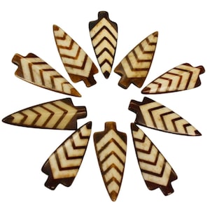 May include: Ten brown and white arrowhead shaped pendants with a chevron pattern.