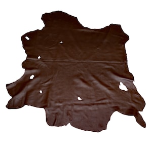 May include: A large piece of brown leather with several holes in it.