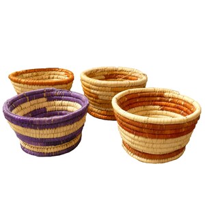 May include: Four woven baskets with different colored stripes. The baskets are made of natural materials and have a rustic look.
