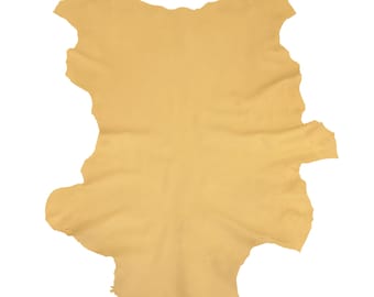 May include: A single piece of tanned leather in a light tan color. The leather has a natural, irregular shape with a slightly textured surface. The edges are uneven, showing the natural cut of the hide. The leather is likely for crafting.
