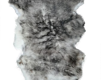 May include: A gray and white rabbit fur rug. The fur is soft and fluffy, and the rug is perfect for adding a touch of luxury to any room.