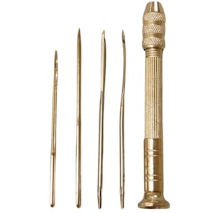 May include: A set of five gold-toned tools for leather crafting. The tools include a leather awl, a stitching awl, a stitching groover, a stitching punch, and a stitching pony.