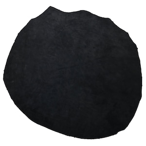 May include: A black suede leather patch, with a slightly irregular shape.