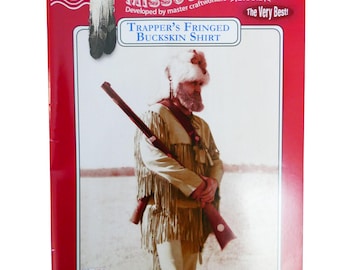 May include: A vintage sewing pattern for a trapper's fringed buckskin shirt. The pattern cover features a man wearing the shirt and holding a rifle. The pattern is from Missouri River, a brand developed by master craftworkers. The pattern number is 4799-500-026.