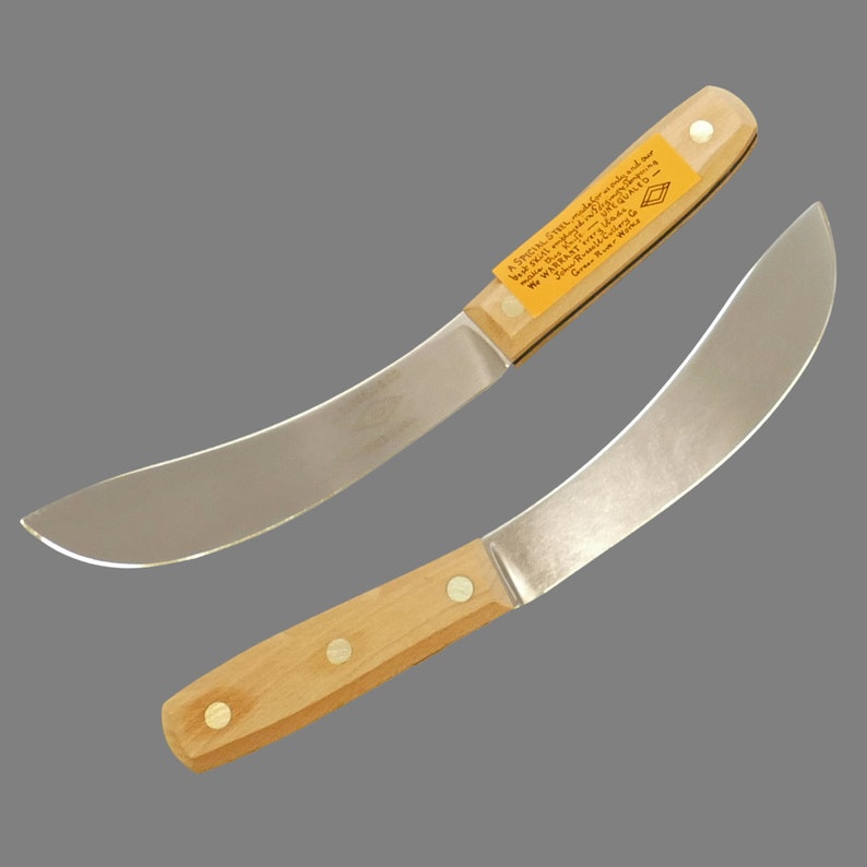 K&ouml;nnte beinhalten: Zwei gebogene Messer mit Holzgriffen. Das obere Messer hat ein gelbes Etikett mit dem Text "A SPECIAL STEEL, made for only and our UNEQUALED WARRANTY -  GUARANTEED FOREVER - Green River, WI 54941".