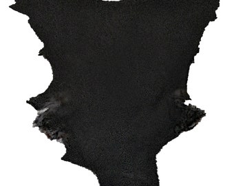 May include: A black leather hide with a rough, textured surface. The hide has an irregular shape with a jagged edge.