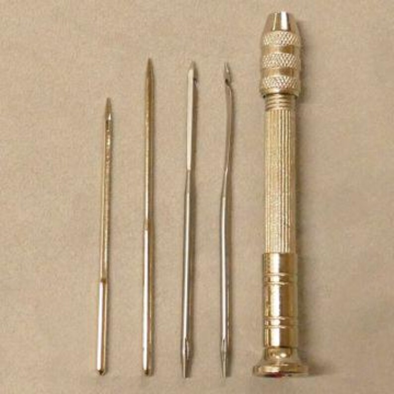 May include: A set of five silver-toned tools for leather crafting. The set includes a hand drill with a textured grip and four different sized awls.
