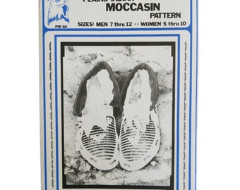 May include: Black and white image of a pattern for making moccasins. The pattern is for sizes 7 through 12 for men and 5 through 10 for women. The text on the pattern reads "Plains Indian Moccasin Pattern".