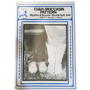 May include: Black and white photo of a pattern booklet for making moccasins. The booklet cover features a photo of two children wearing moccasins. The text on the cover reads "Child's Moccasin Pattern Hightop & Regular/Hard & Soft Sole SIZES: 4 thru 13; 1 thru 6"