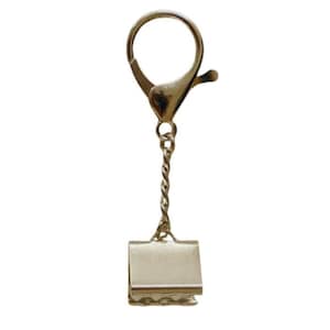 May include: Silver key chain with a clip on the end. The clip is attached to a silver chain and a silver swivel hook.