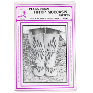 May include: Black and white photo of a pair of high-top moccasins with a geometric design. The pattern is titled "Plains Indian Hi-Top Moccasin Pattern" and includes the sizes "Women 5 thru 10 - Men 7 thru 12".