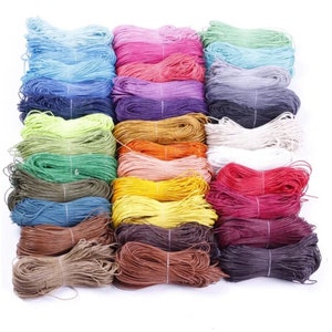 May include: A collection of 24 spools of waxed cotton cord in various colors, including blue, pink, green, yellow, red, brown, and white. The cord is wound tightly on each spool.