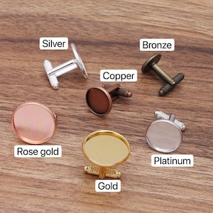 May include: Set of 10 cufflinks in various finishes, including silver, bronze, copper, rose gold, gold, and platinum. Each cufflink features a round, blank, glass-like insert.