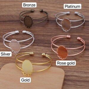 Puede incluir: Cinco pulseras de doble fila con cabujones de vidrio ovalados. Las pulseras son de diferentes colores: bronce, platino, plata, oro rosa y oro.