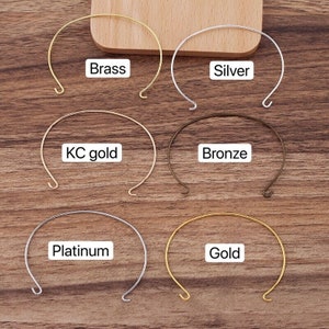 Könnte beinhalten: Sechs unterschiedlich farbige Metallreifen, beschriftet mit ihrem Metalltyp: Messing, Silber, KC-Gold, Bronze, Platin und Gold.