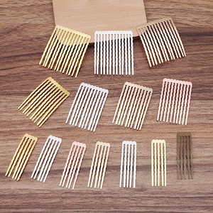 Peut inclure: Assortiment de 12 petits peignes à cheveux en métal de différentes couleurs, dont l'or, l'argent, l'or rose et le bronze. Les peignes ont un design ondulé et sont disposés en rangées sur une surface en bois.