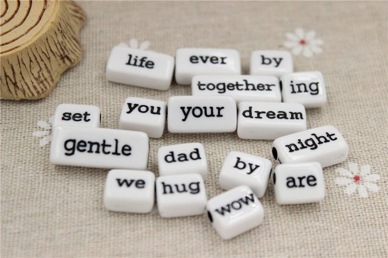 May include: White ceramic tiles with black lettering spelling out the words "life", "ever", "by", "set", "together", "ing", "you", "your", "dream", "gentle", "dad", "we", "hug", "wow", "by", "night", and "are".