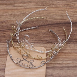 Puede incluir: Tres diademas de alambre plateado y dorado con un diseño decorativo de espiral. Las diademas están retorcidas y tienen un aspecto delicado y femenino.