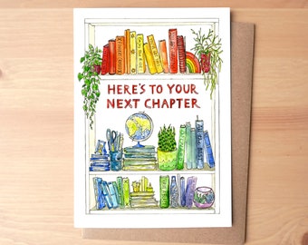 May include: A white card with a watercolor illustration of a bookshelf filled with colorful books. The books have titles like "You Are Amazing!" and "Enjoy the Ride." The text "HERE'S TO YOUR NEXT CHAPTER" is written in red on the card.