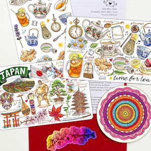 May include: A collection of illustrated stationery items including two sheets of tea-themed stickers, a Japan-themed sticker sheet with landmarks and cultural icons, a circular mandala sticker, and a cherry blossom sticker on a red envelope.