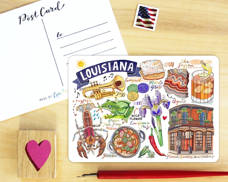 Op de afbeelding: Een kleurrijke illustratie van de cultuur van Louisiana met een rivierkreeft, een groene boomkikker, een gumbo-pot, beignets, een trompet, een Sazerac-cocktail, een wilde iris en een gebouw in de Franse wijk van New Orleans. De tekst "Louisiana" staat in een blauwe banner bovenaan de illustratie.