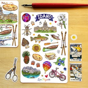 May include: A collection of stickers featuring Idaho-themed illustrations. The stickers include images of the state capitol building, a potato, a bee, a fish, a bicycle, and the text "IDAHO". Also included are two U.S. Postal Service stamps.