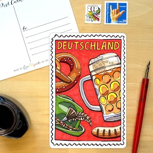May include: A rectangular postcard featuring a vibrant illustration of a beer stein, a pretzel, a green alpine hat with a feather, and a sausage against a red background. The word DEUTSCHLAND is printed in yellow at the top of the stamp-shaped design.