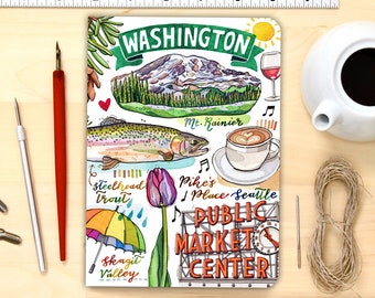 May include: A colourful illustration of a Seattle, Washington themed notebook. The notebook features a watercolour illustration of Mount Rainier, a salmon, a coffee cup, a tulip, a rainbow umbrella, and the Pike Place Market sign. The text "WASHINGTON" is written in a green banner at the top of the notebook.