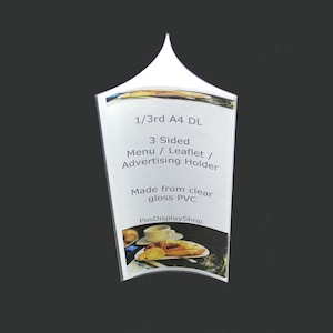 May include: A clear, glossy PVC advertising holder. The text on the holder reads "1/3rd A4 DL" and "3 Sided Menu / Leaflet / Advertising Holder." The base has a printed image of food and drink.