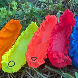 May include: Five colorful fabric pouches with drawstring closures. The pouches are orange, yellow, red, red, and blue.