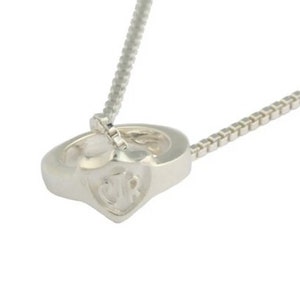 May include: Silver necklace with a heart-shaped pendant featuring the initials "JR" engraved on the front.